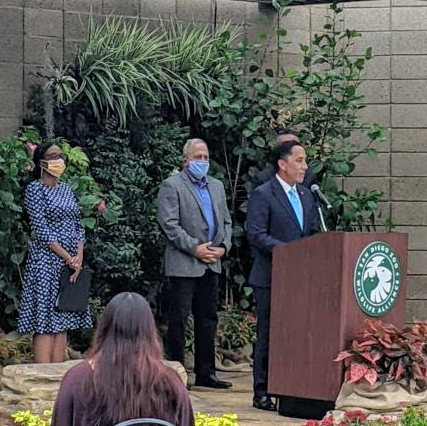 Councilmember Montgomery, Peter Callstrom and Mayor Todd Gloria stand at podium at San Diego Zoo